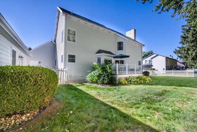 rear view of house featuring a lawn