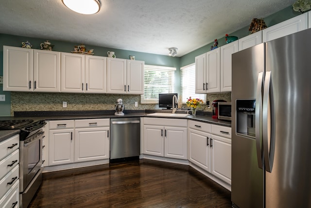 kitchen with white cabinetry, dark hardwood / wood-style flooring, sink, appliances with stainless steel finishes, and a textured ceiling