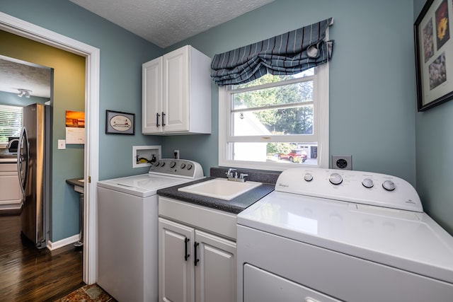 clothes washing area with plenty of natural light, dark hardwood / wood-style floors, sink, and a textured ceiling