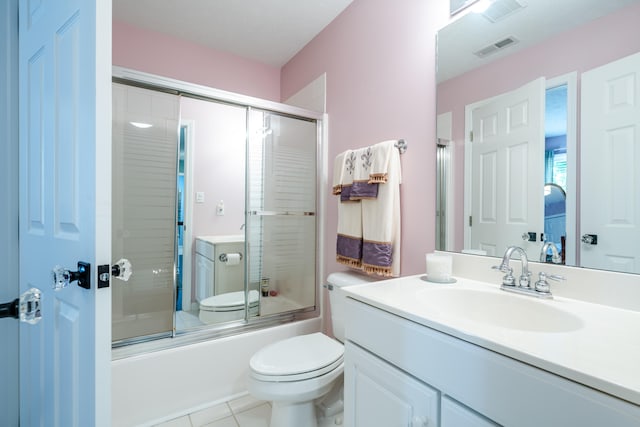 full bathroom featuring toilet, vanity, tile patterned flooring, and shower / bath combination with glass door