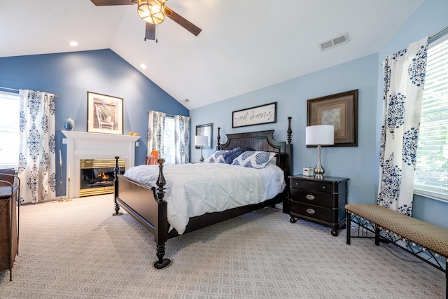 bedroom with ceiling fan, vaulted ceiling, and light colored carpet