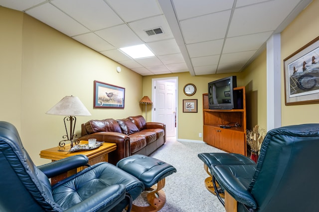 carpeted living room with a paneled ceiling