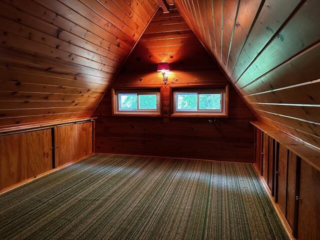 bonus room with wood ceiling, lofted ceiling, and wood walls