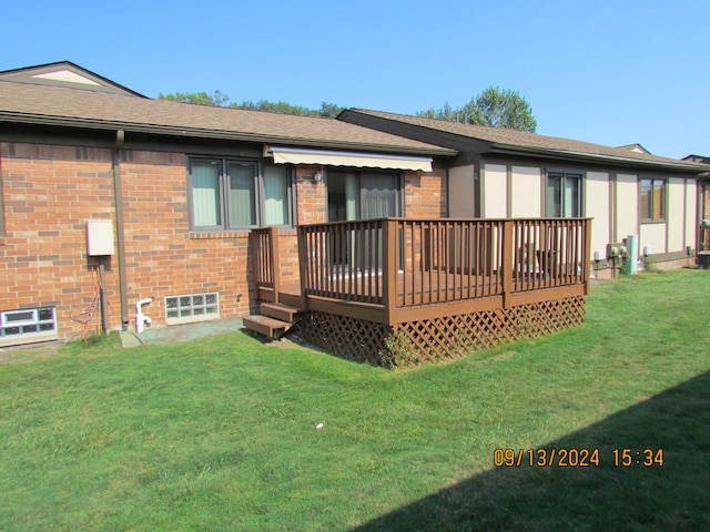 rear view of property with a wooden deck and a yard