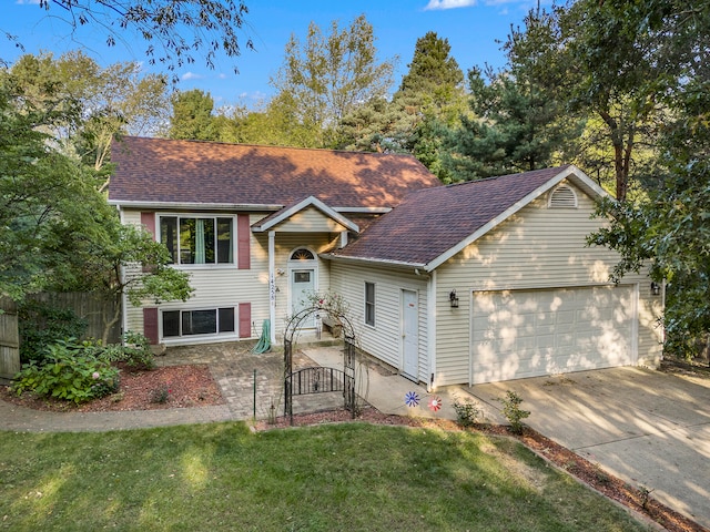 raised ranch featuring a garage and a front lawn