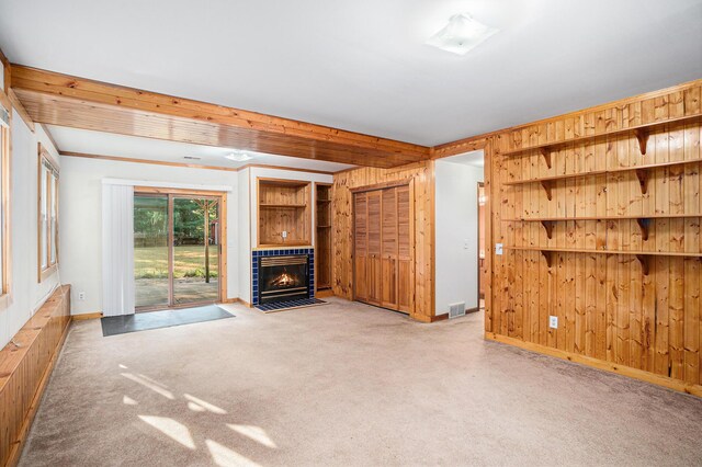 unfurnished living room with carpet flooring and wooden walls