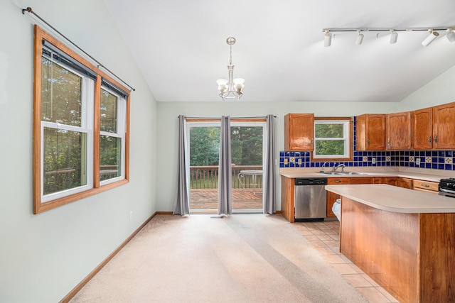 kitchen with pendant lighting, vaulted ceiling, stainless steel dishwasher, and track lighting