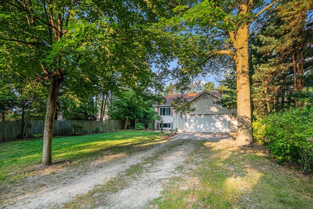 obstructed view of property with a front yard and a garage