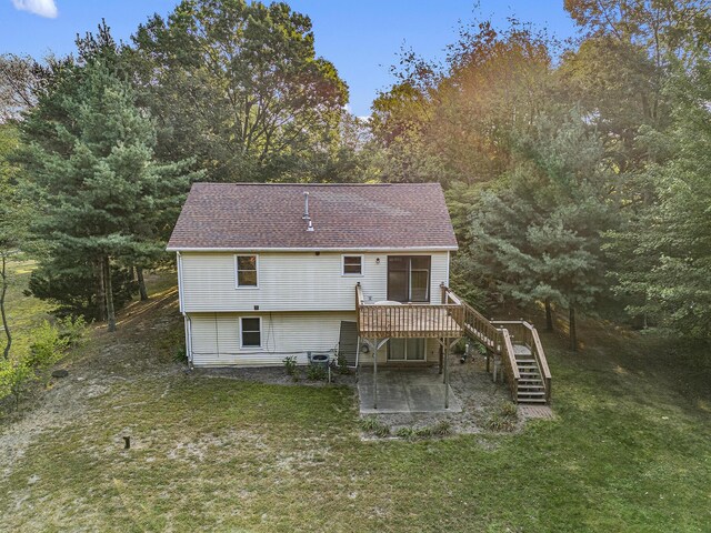 back of property featuring a deck and a lawn