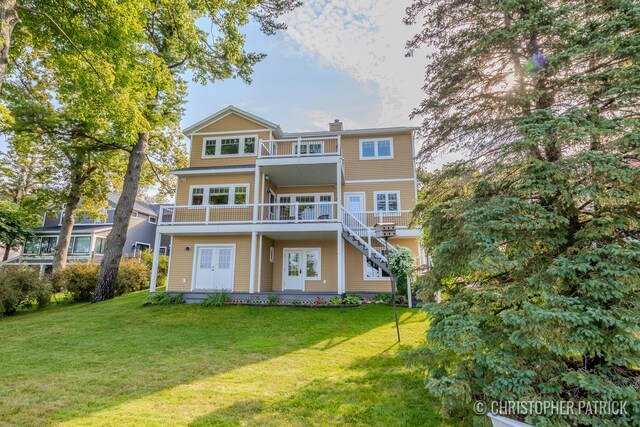 back of house featuring a yard and a balcony