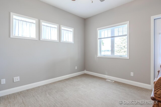 unfurnished room with light colored carpet and ceiling fan