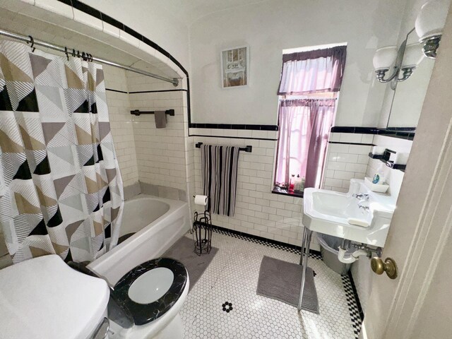 bathroom with tile walls, shower / bath combo, radiator, tile patterned floors, and toilet