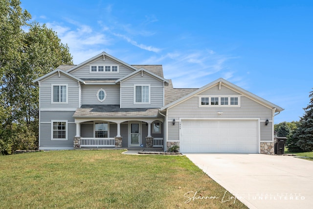 craftsman-style home featuring covered porch, a garage, and a front lawn