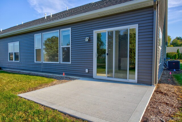 back of house featuring cooling unit, a yard, and a patio