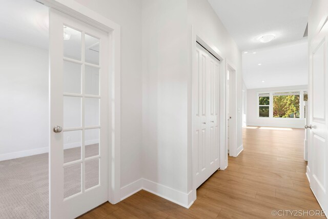 corridor with light hardwood / wood-style floors