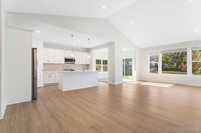 unfurnished living room featuring sink, high vaulted ceiling, and light hardwood / wood-style flooring