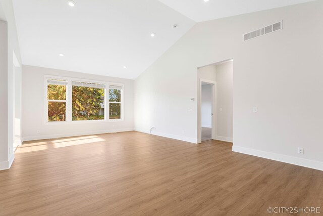 unfurnished room featuring light hardwood / wood-style flooring and high vaulted ceiling