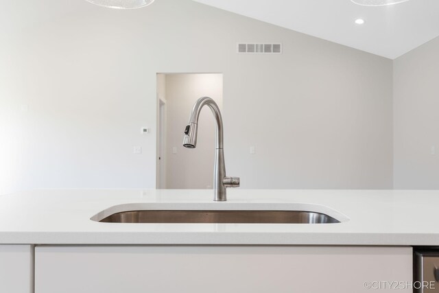 room details featuring white cabinets and sink