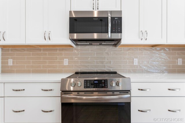 kitchen featuring white cabinets, appliances with stainless steel finishes, and backsplash