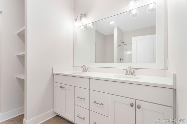 bathroom with tile patterned flooring, vanity, and walk in shower