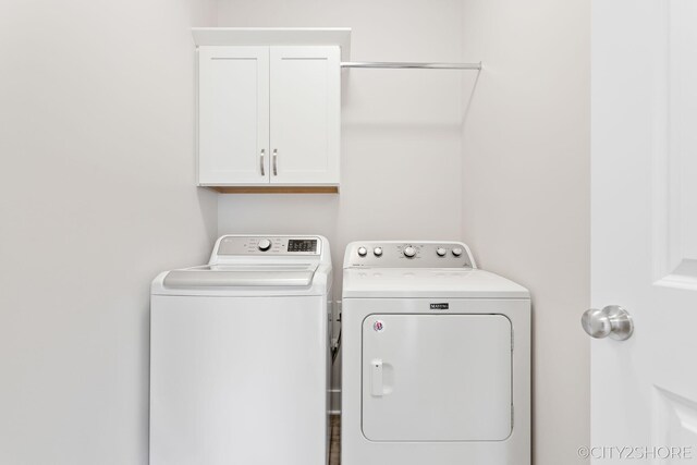 laundry area with cabinets and washing machine and clothes dryer