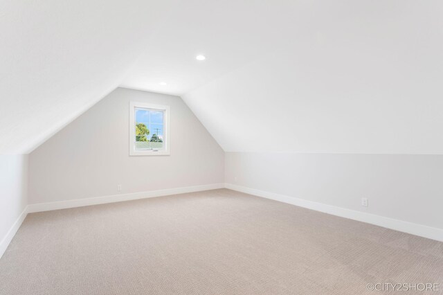 bonus room featuring light colored carpet and lofted ceiling