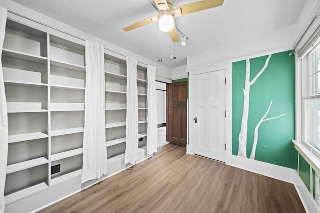 interior space with multiple windows, ceiling fan, and hardwood / wood-style flooring