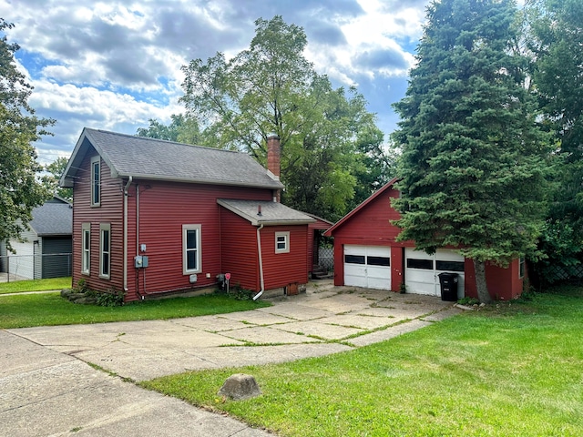 view of front of house featuring a garage, an outdoor structure, and a front yard