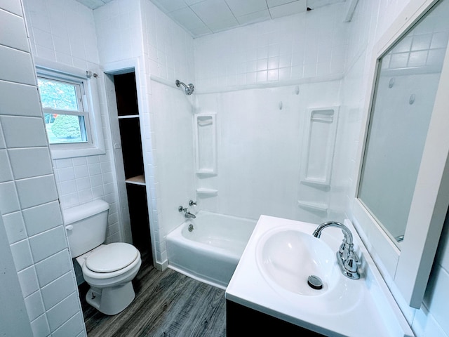 full bathroom with hardwood / wood-style floors, bathtub / shower combination, toilet, tile walls, and vanity