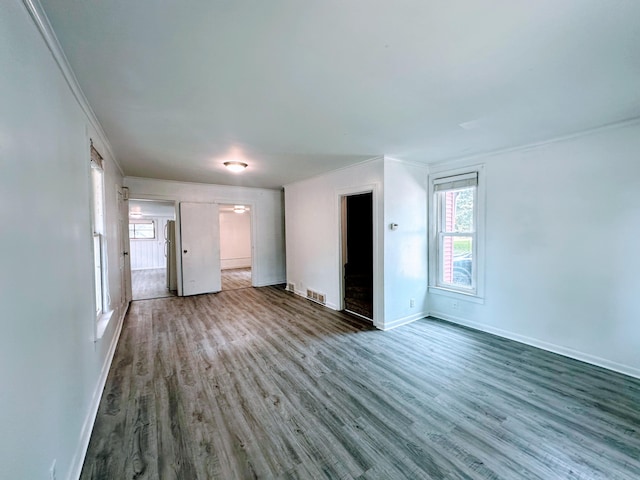 unfurnished living room with hardwood / wood-style floors and ornamental molding