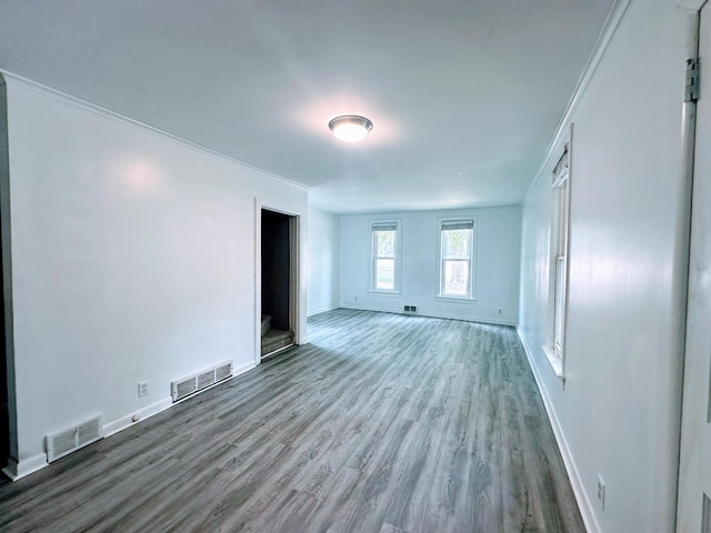 spare room with ornamental molding and wood-type flooring