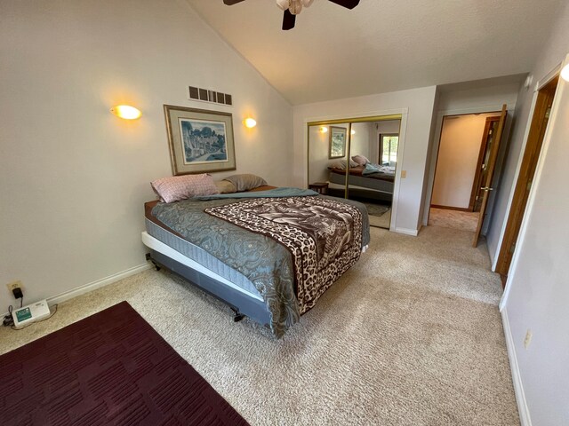 bedroom featuring ceiling fan, a closet, light carpet, and lofted ceiling