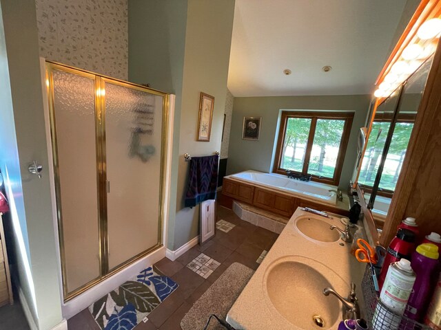 bathroom featuring vanity, separate shower and tub, vaulted ceiling, and tile patterned floors