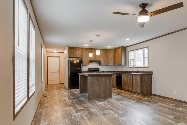 kitchen with hanging light fixtures, hardwood / wood-style flooring, black appliances, ceiling fan, and a kitchen island