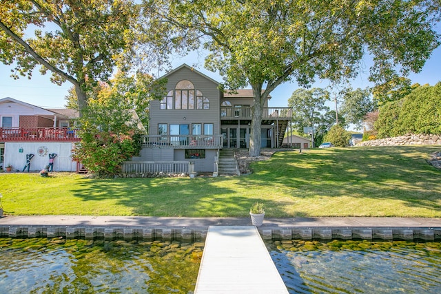 back of house featuring a lawn and a deck with water view