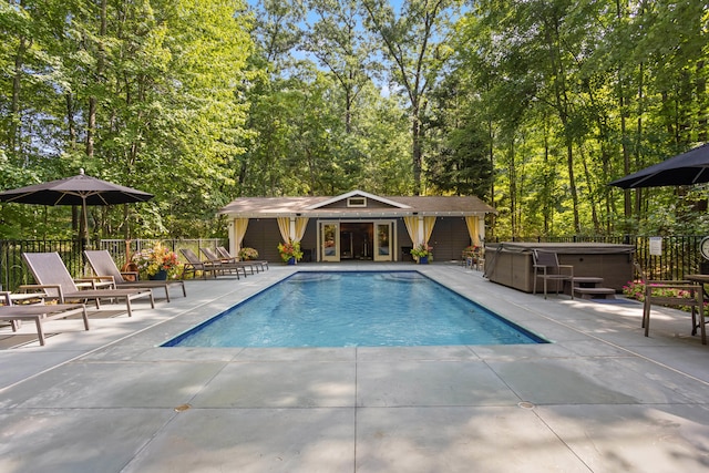 view of pool with a hot tub and a patio