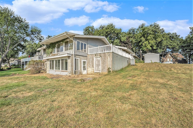 back of property featuring a balcony and a yard