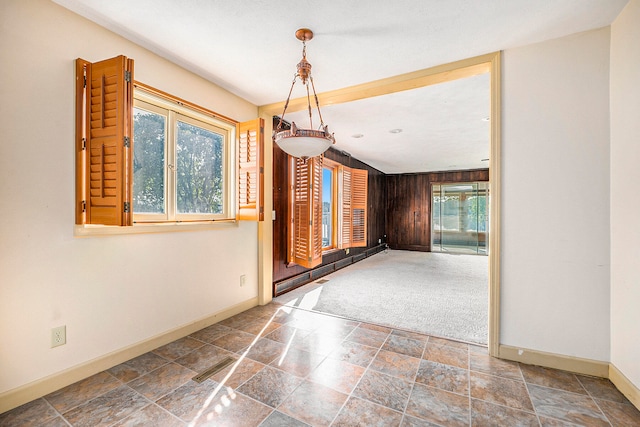 unfurnished dining area with wood walls