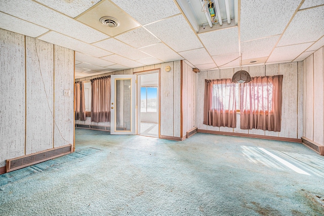 spare room featuring a drop ceiling and carpet floors