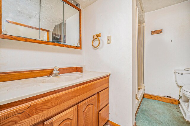 bathroom featuring a textured ceiling, vanity, toilet, and a shower