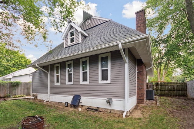 view of home's exterior featuring a lawn and central AC