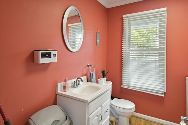 bathroom featuring vanity, toilet, ornamental molding, and hardwood / wood-style floors