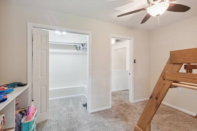 bedroom featuring light colored carpet, ceiling fan, and a closet