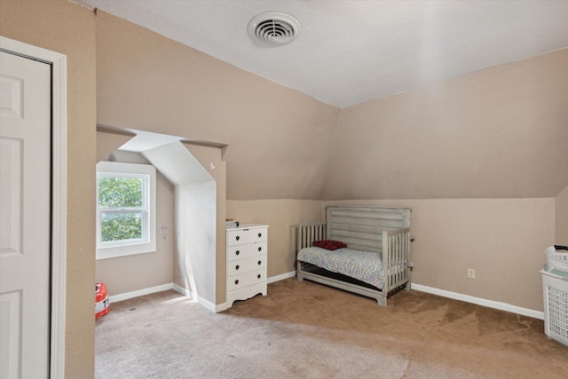 unfurnished bedroom with lofted ceiling, carpet flooring, and a textured ceiling