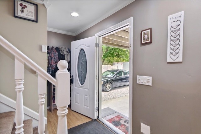 foyer featuring crown molding and light hardwood / wood-style floors