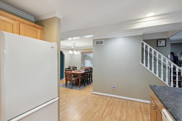 kitchen featuring white appliances, a notable chandelier, light hardwood / wood-style floors, crown molding, and light brown cabinets