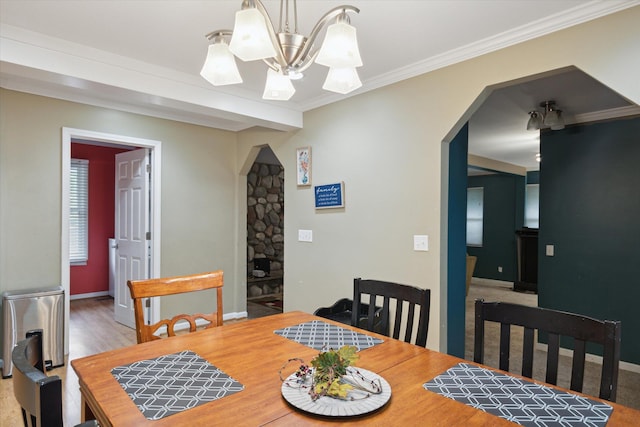 dining area with crown molding, wood-type flooring, and a notable chandelier