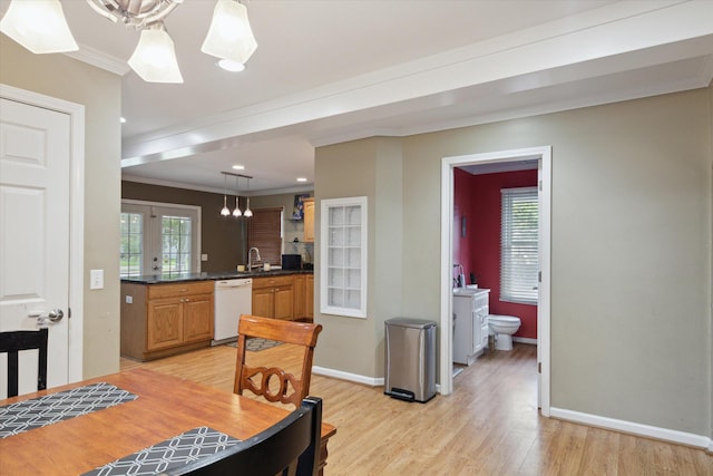 dining space with light wood-type flooring, ornamental molding, and sink