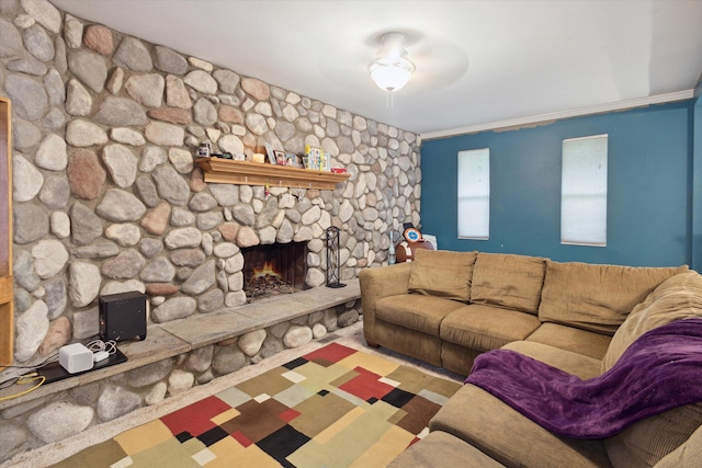 living room with ceiling fan, a fireplace, and ornamental molding