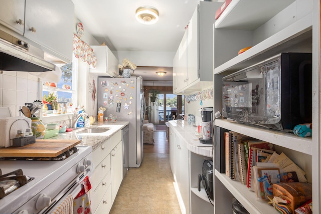 kitchen with white cabinets, appliances with stainless steel finishes, sink, and decorative backsplash